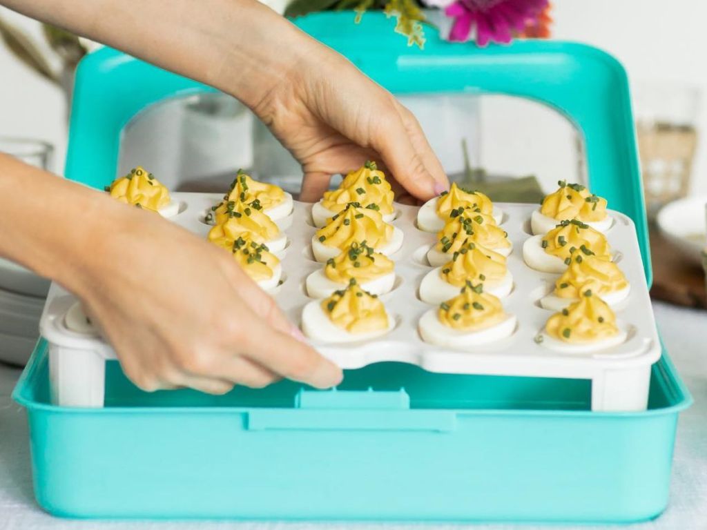 Hand setting a Fancy Panz Deviled Egg tray into a carrier