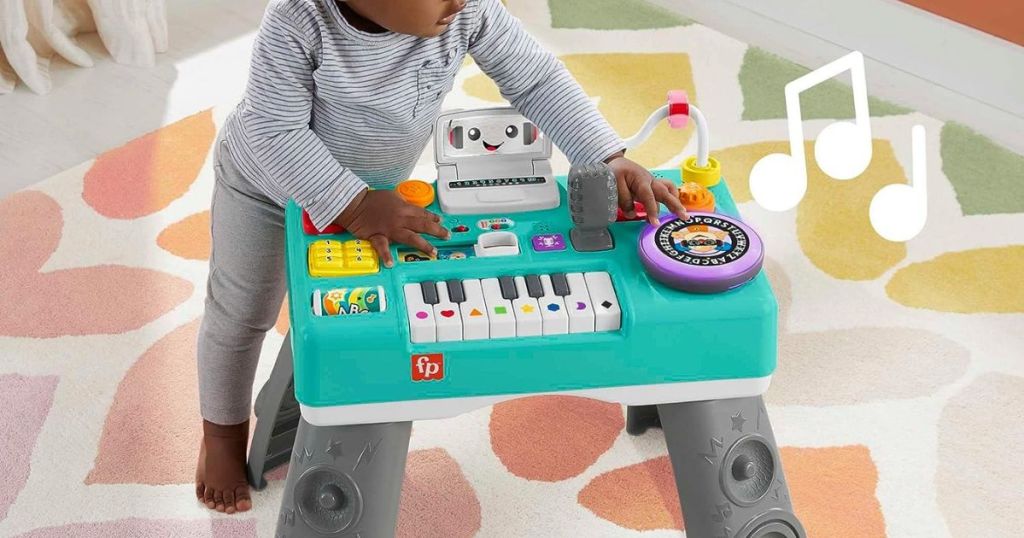Toddler playing with a Fisher Price DJ Table