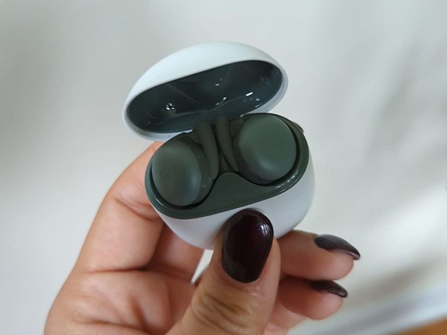 A hand holding a Google Pixel Buds A-Series in green