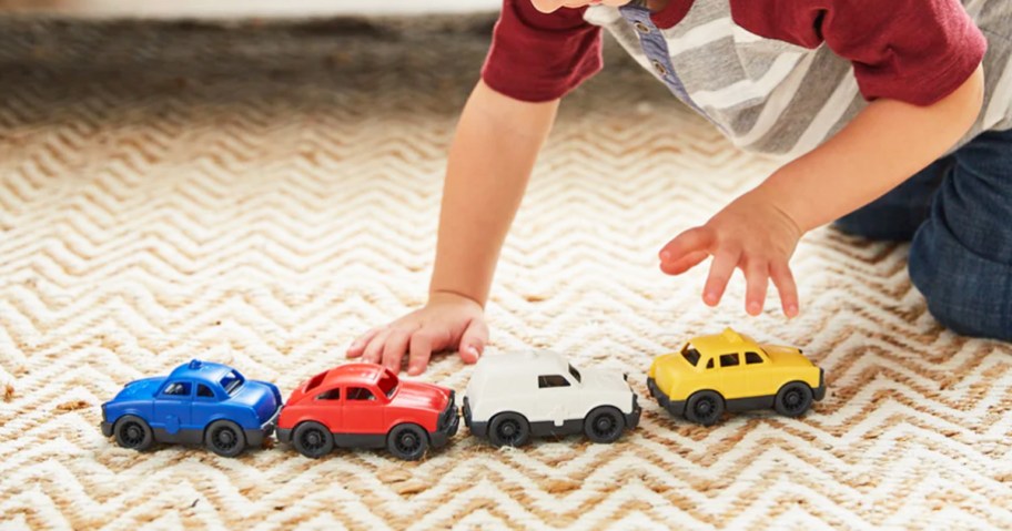 Child playing with 4 Green Toys mini cars