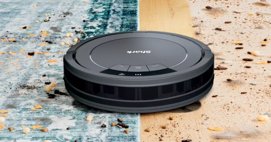 Shark robot vacuum vacuuming a green stripe rug and moving to a hardwood floor