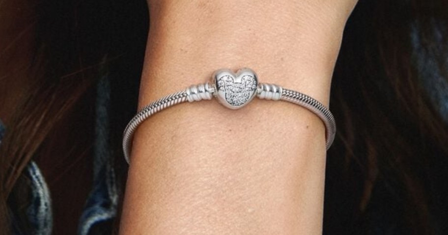 woman's wrist wearing a silver Pandora Mickey Mouse head charm bracelet