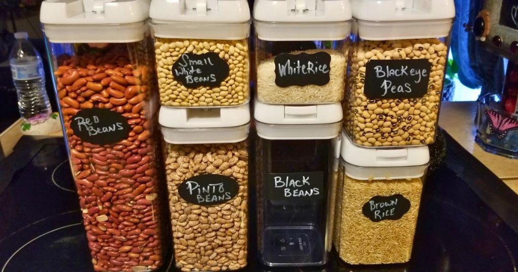 7 clear food storage containers filled with different types of beans and rice