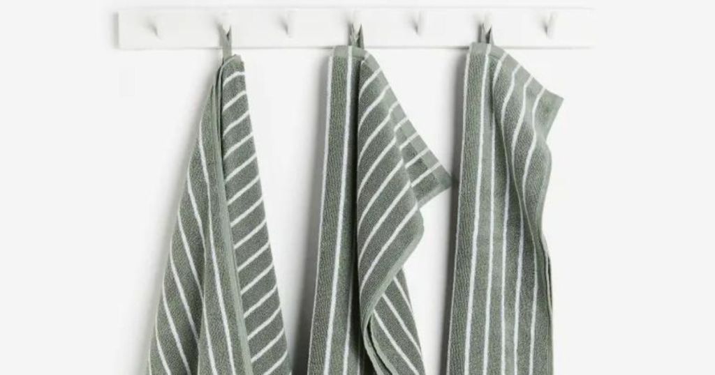 green towels with white strips hanging on hooks