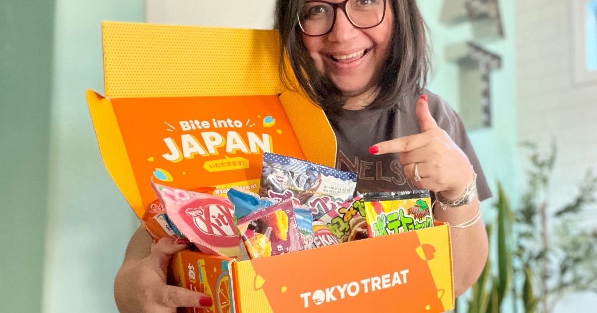 Lina holding an open Tokyo Treat Surprise Box showing off the snacks
