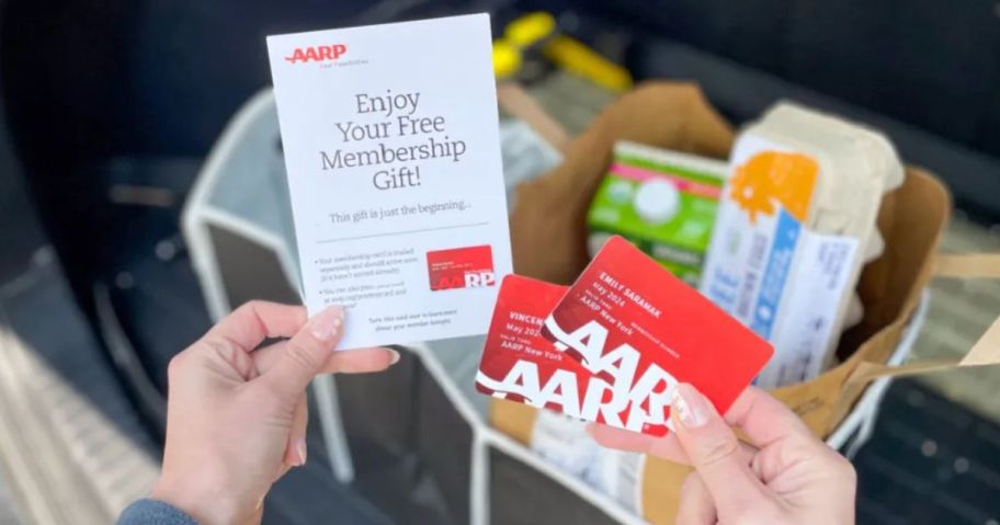 hands holding AARP Membership cards and welcome letter with the Free Trunk Organizer shown in the background