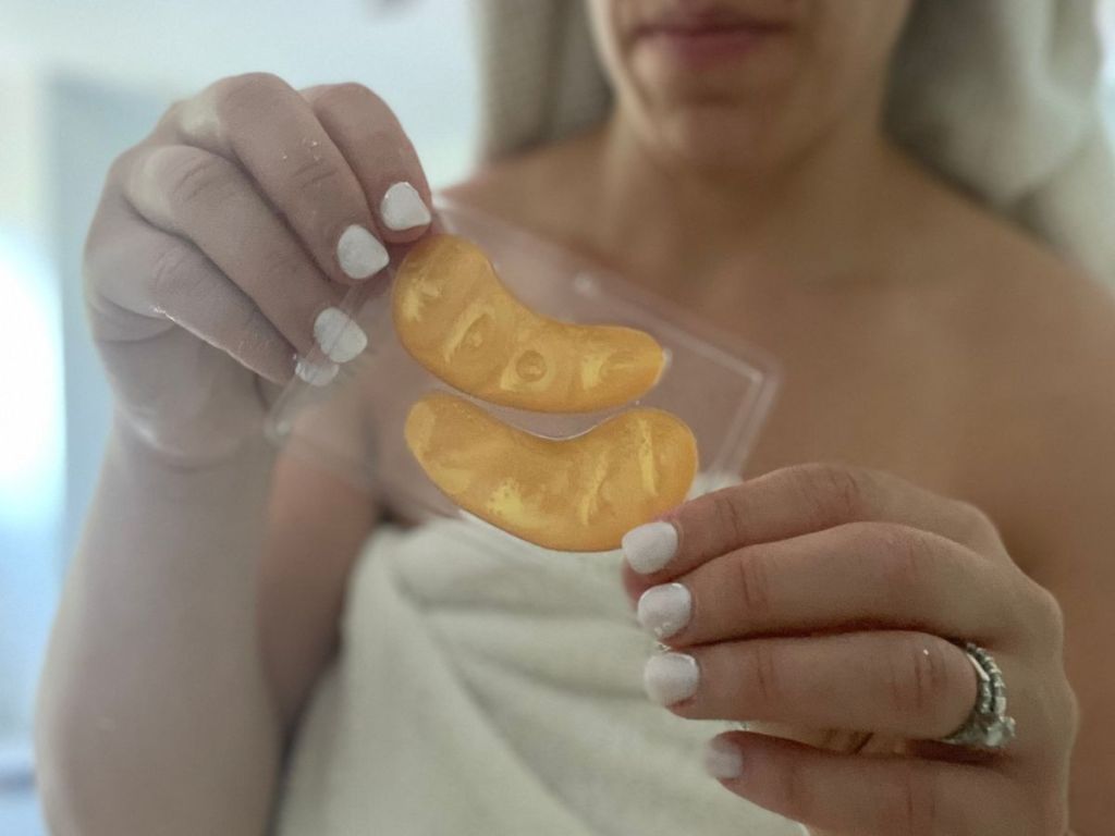 woman holding a pair of Golden Glow Eye Masks