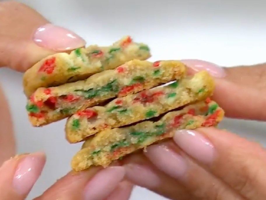 woman holding up holiday sugar cookies