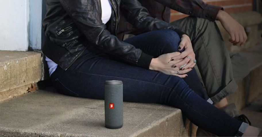 JBL Flip essentials 2 speaker on a cement stoop