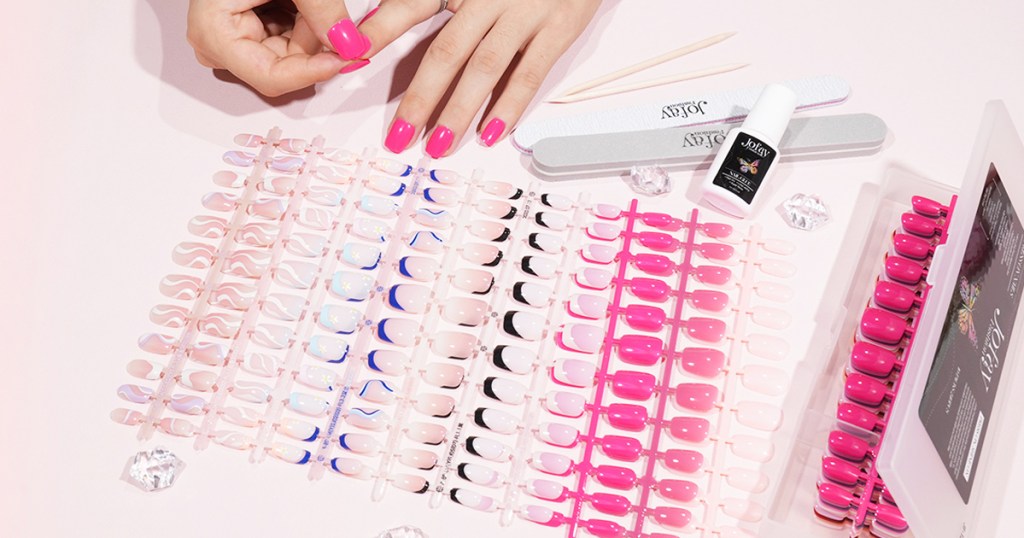 large set of press-on nails in various colors with nail glue, nail files, and cuticle sticks