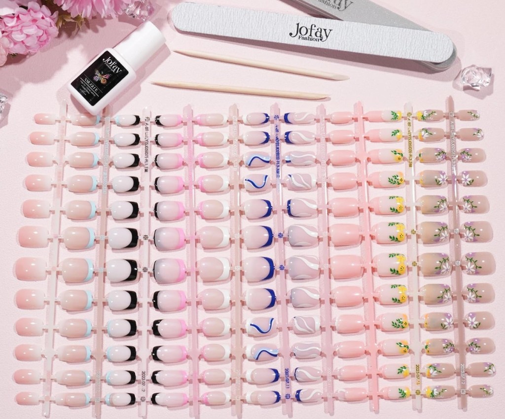 large set of press-on nails in various colors with nail glue, nail files, and cuticle sticks