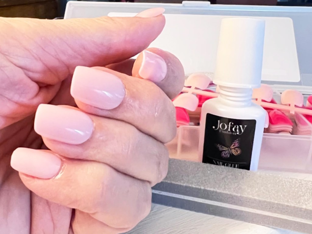 woman's hand with light pink press-on nails