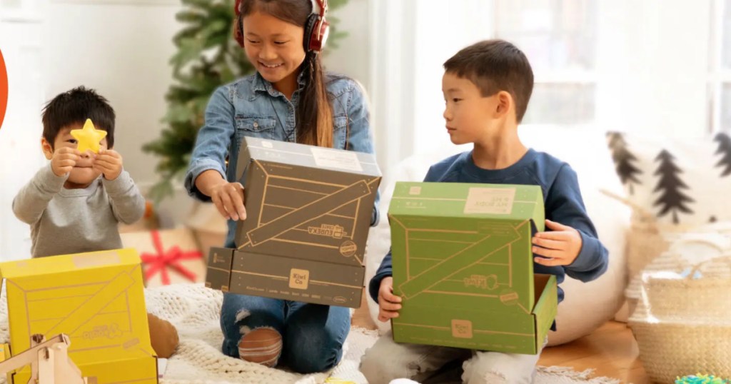 kids opening kiwi co boxes by christmas tree