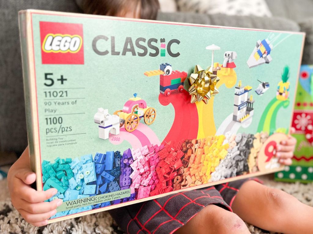 Little boy holding a LEGO Classic 90 Years Set
