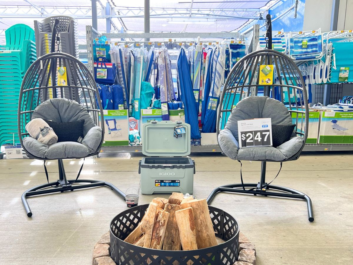 2 wicker hanging egg chairs with Igloo cooler between them and firepit on display at Walmart