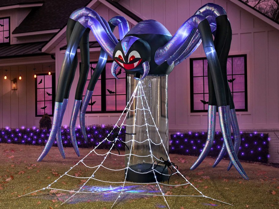 large black and purple inflatable spider with web in front yard