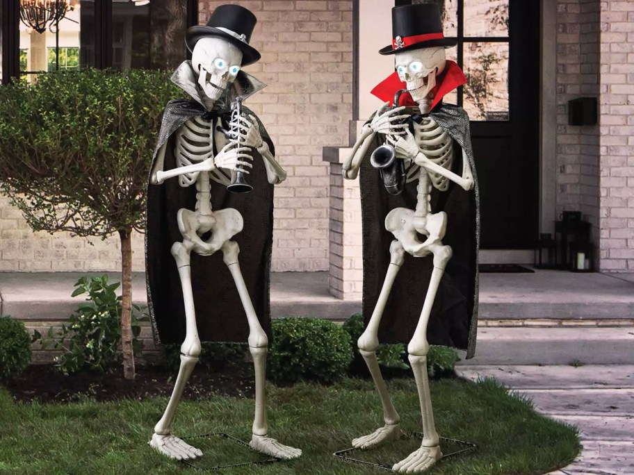 skeletons in top hats and capes playing musical instruments on front yard