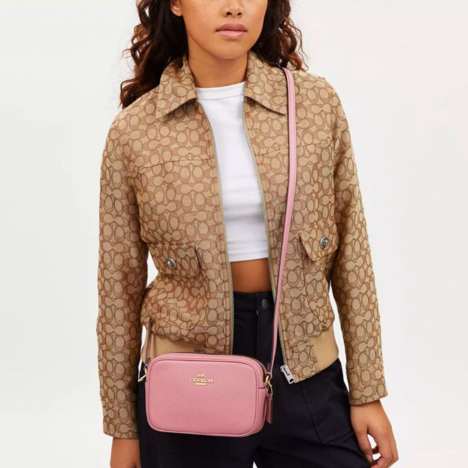 a model wearing a coach Mini Jamie Camera Bag in True Pink crossbody style