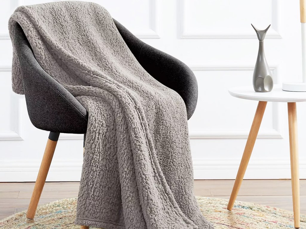 grey sherpa throw draped on an accent chair