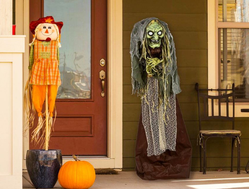 green witch on front porch with scarecrow