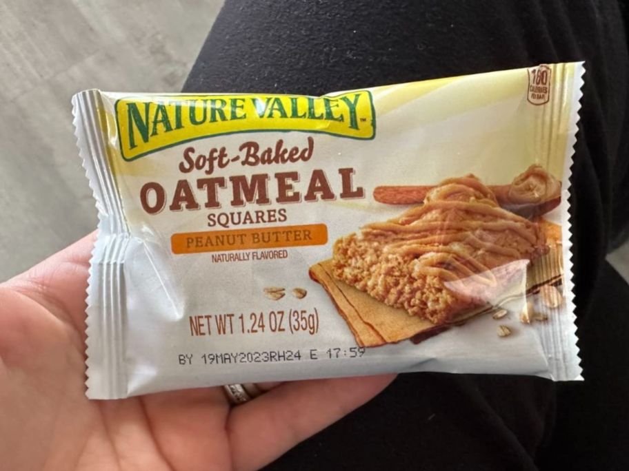A person holding a Nature Valley Soft-Baked Oatmeal Square in Peanut Butter