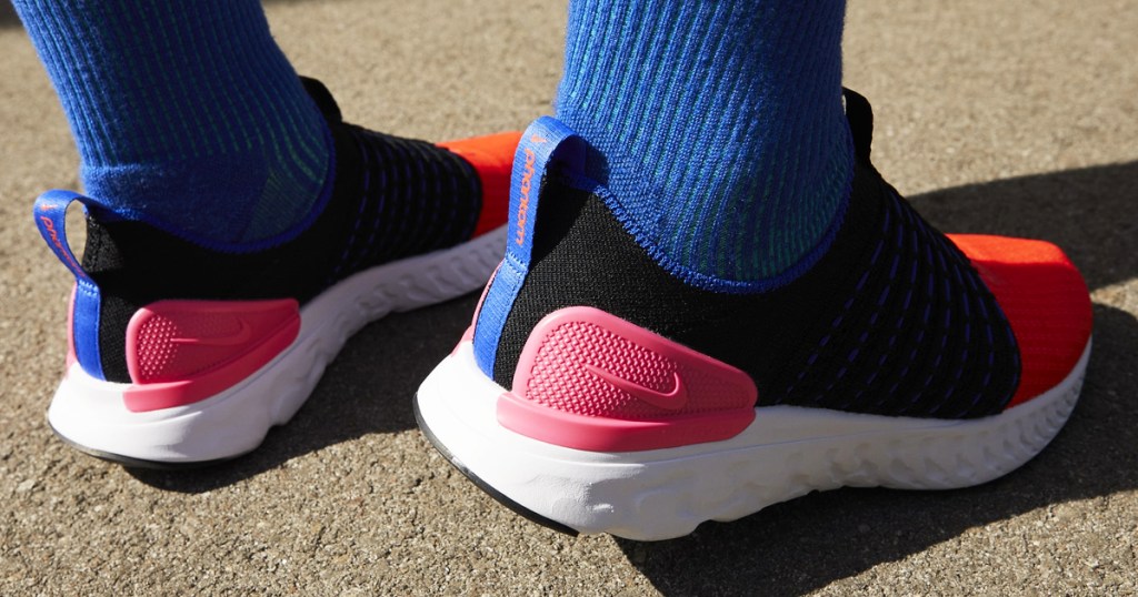 person wearing blue socks with red, pink, and black nike shoes