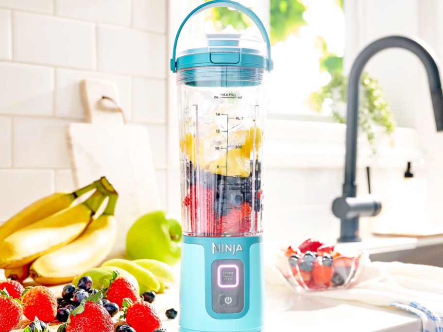 bright blue ninja personal blender on counter with fruit inside