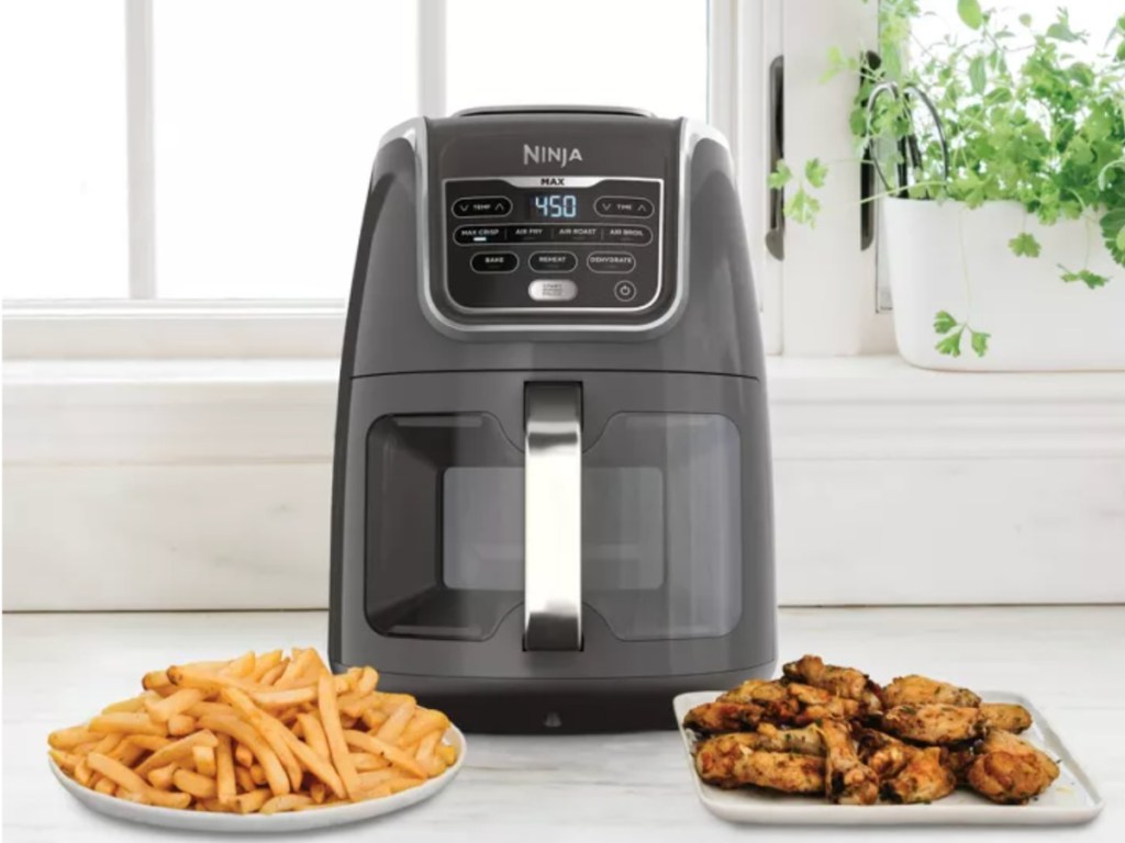 black air fryer in front of french fries and chicken wings