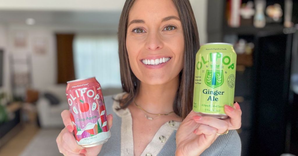 woman holding two cans of olipop soda