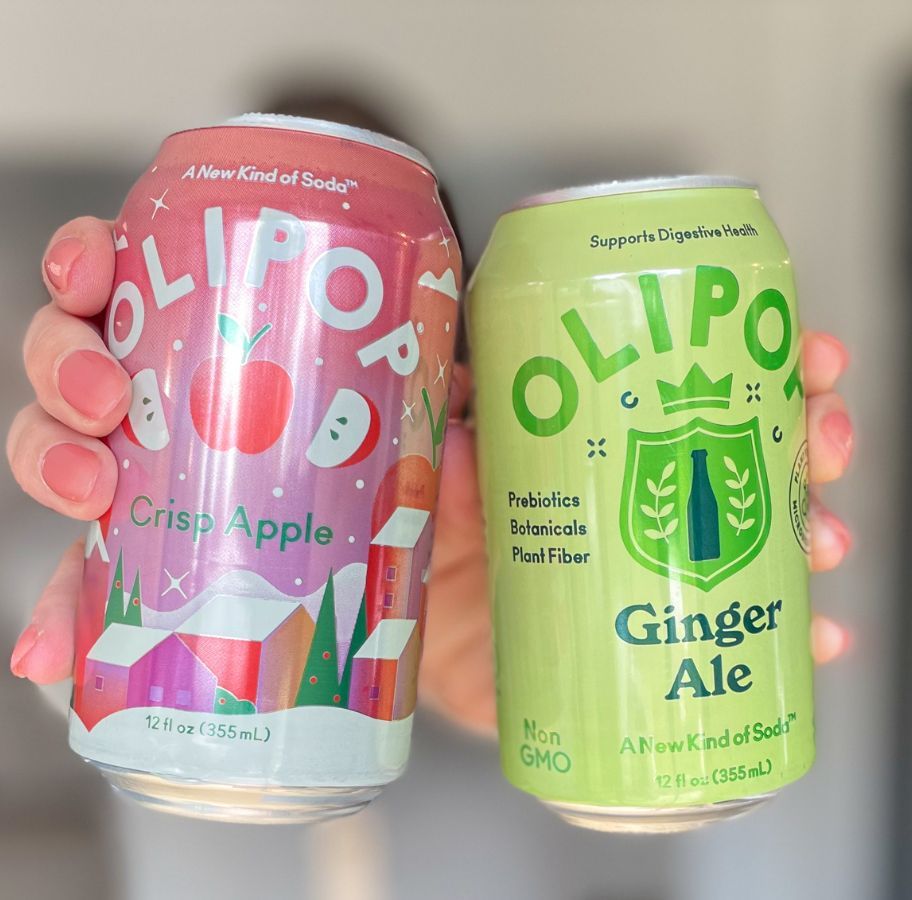 hands holding 2 cans of Olipop Soda up to the camera