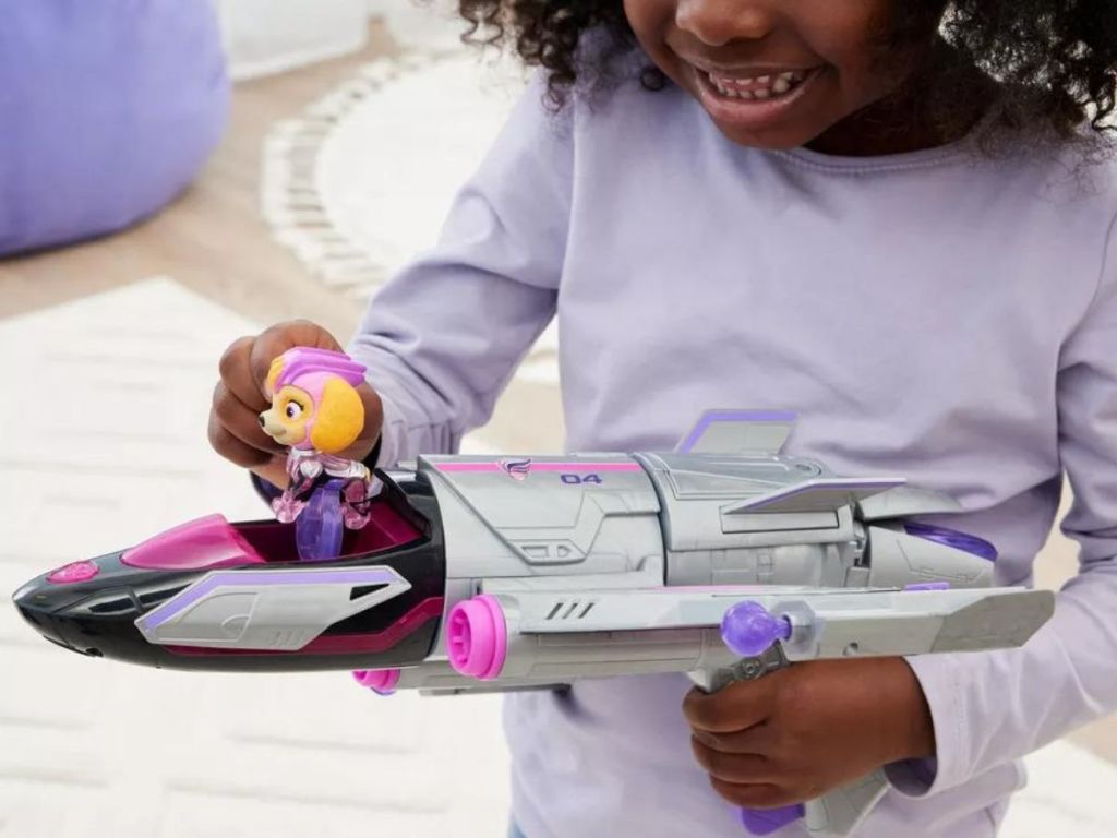 Little girl holding the PAW Patrol: The Mighty Movie Skye Rescue Jet