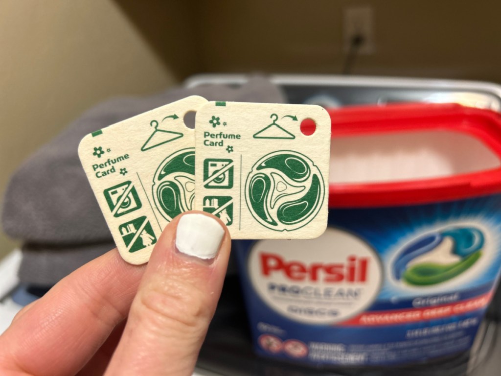 person holding up 2 Persil Perfume Cards