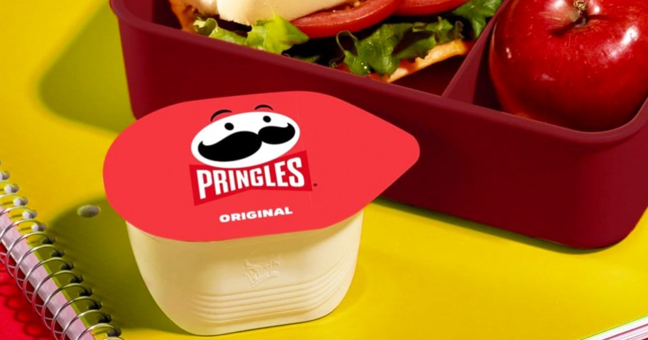 small can of pringles next to lunchbox