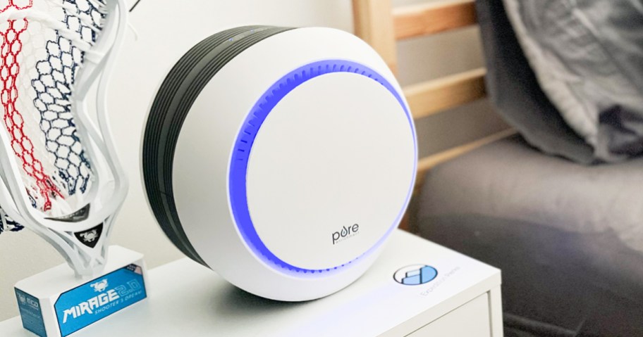 round white air purifier with blue light on nightstand
