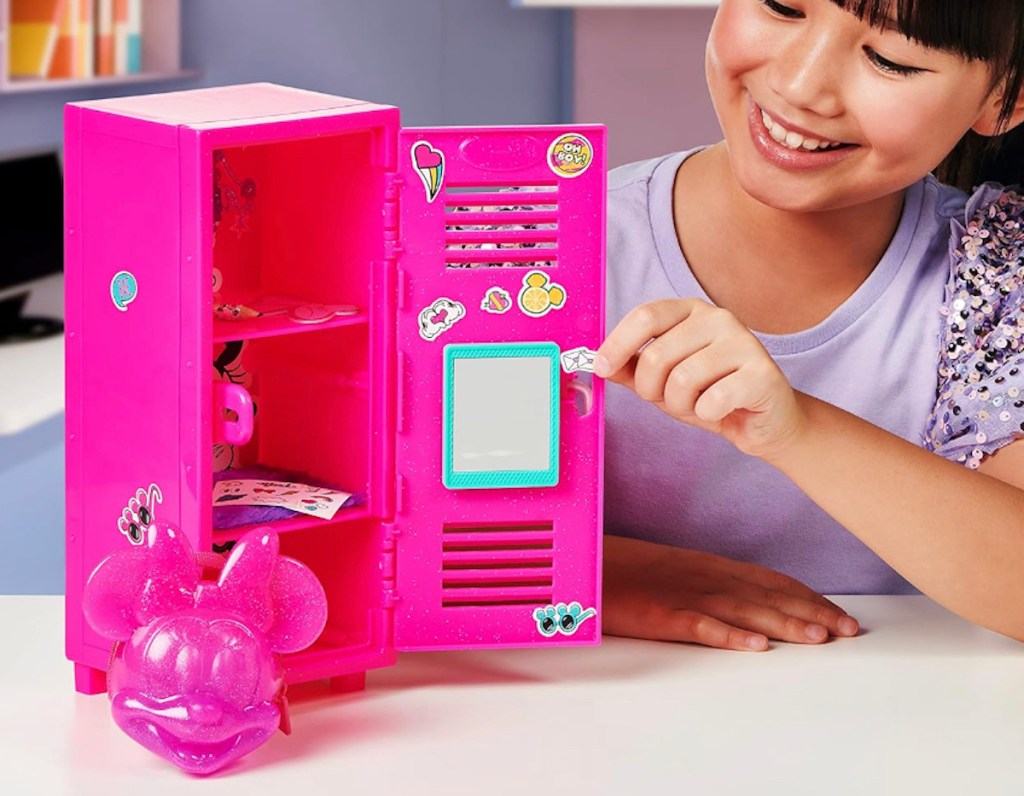 girl sitting at table opening hot pink locker
