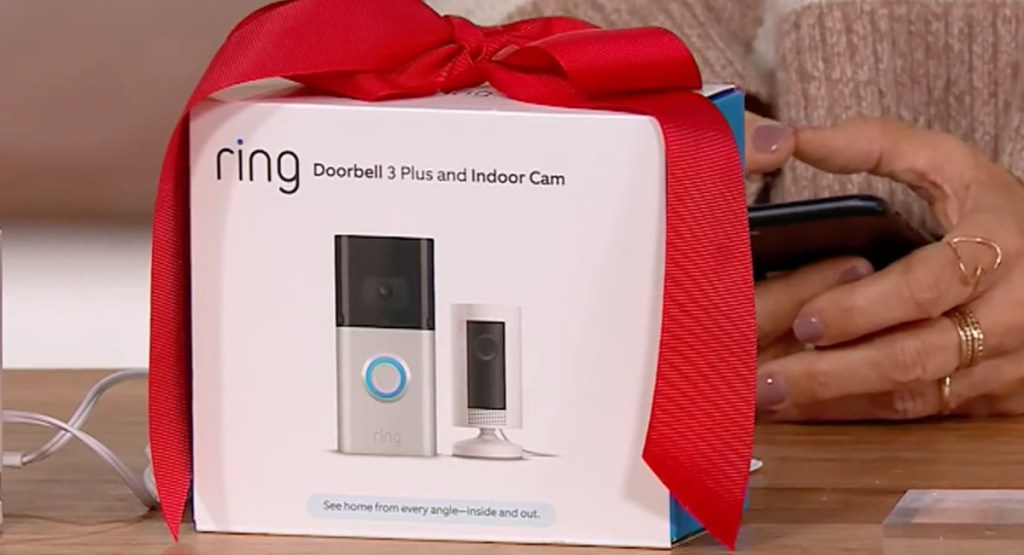 Ring doorbell 3 plus and indoor cam displayed inside its box with red ribbon on the table