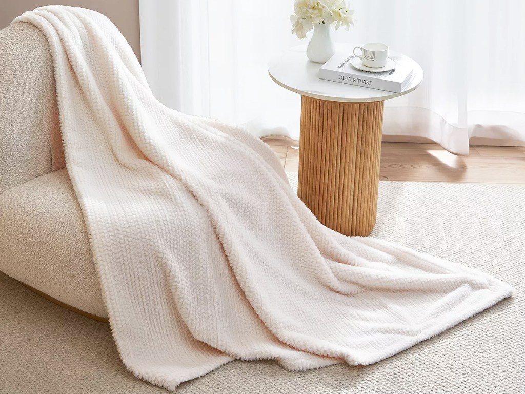 white throw blanket draped on couch and floor