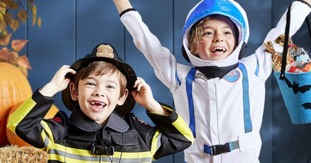 Two kids dressed in costumes as a fireman and an astronaut