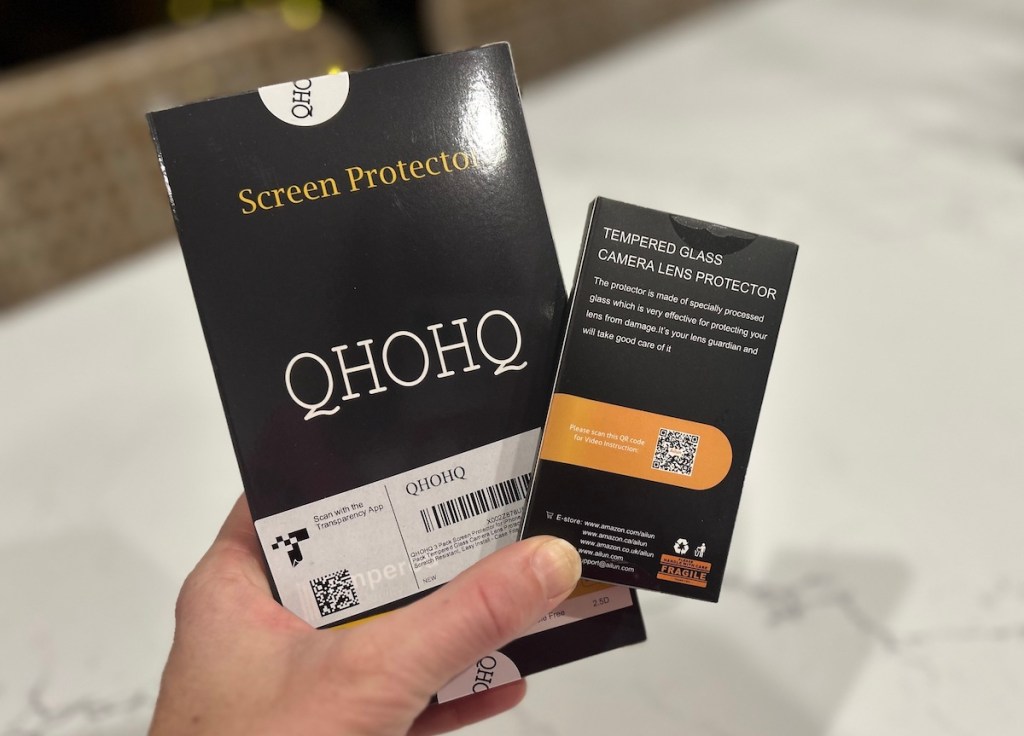 Hand holding new screen protectors in box