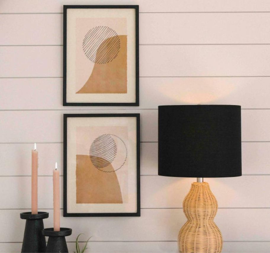two sun and moon graphic prints on a wall by a table lamp