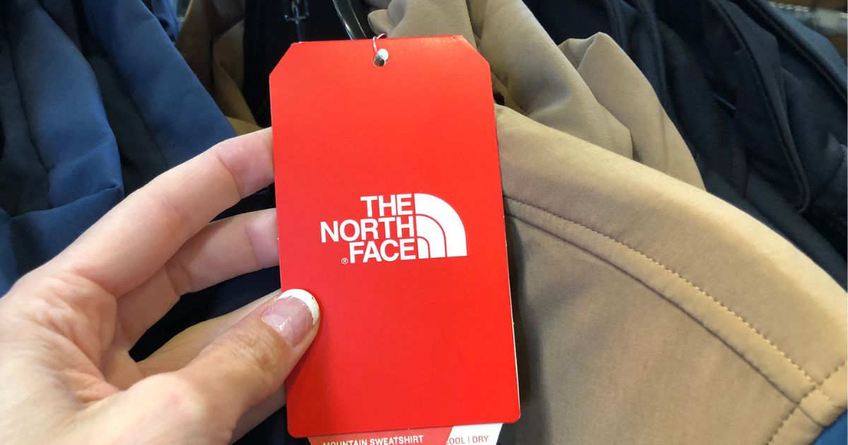 Hand holding a The North Face Tag