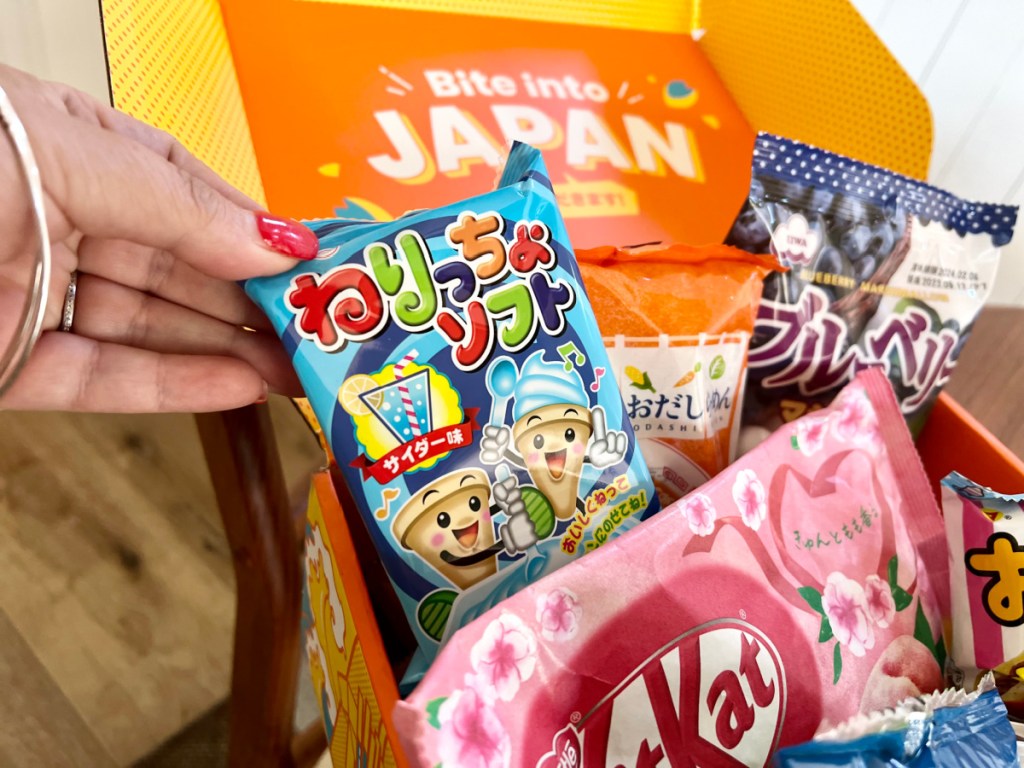 person pulling japanese snack out of treat box