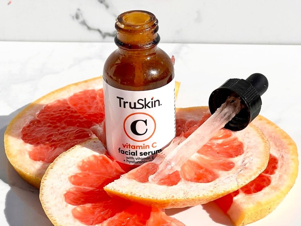 opened bottle of TruSkin Vitamin C Face Serum surrounded by slices of grapefruit