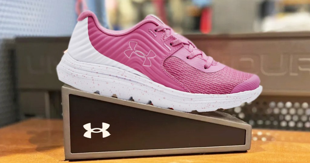 pink and white under armour running shoe on display in store