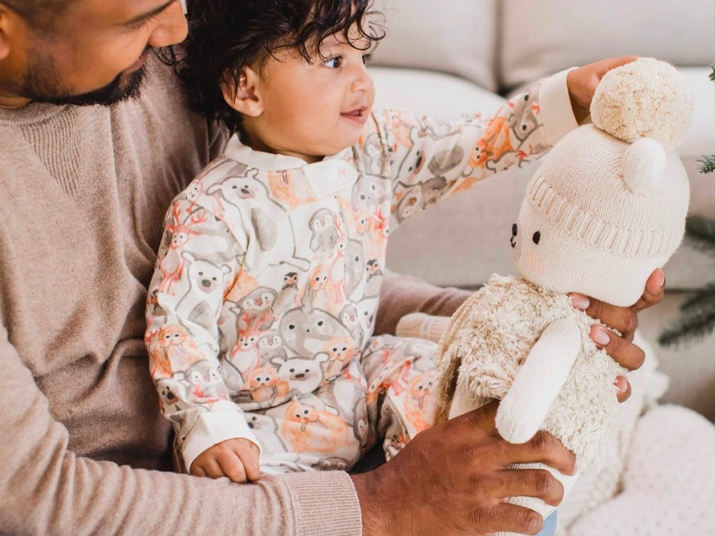 baby wearing arctic animal pajamas in dads lap with bear
