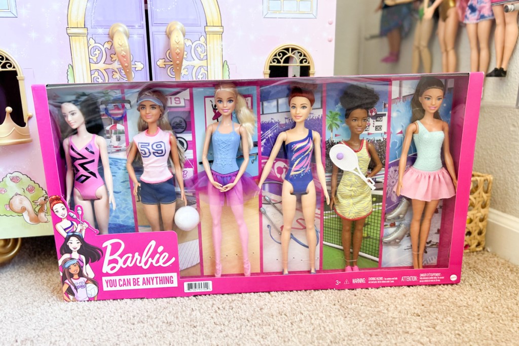 6 pack of barbie dolls next to doll castle