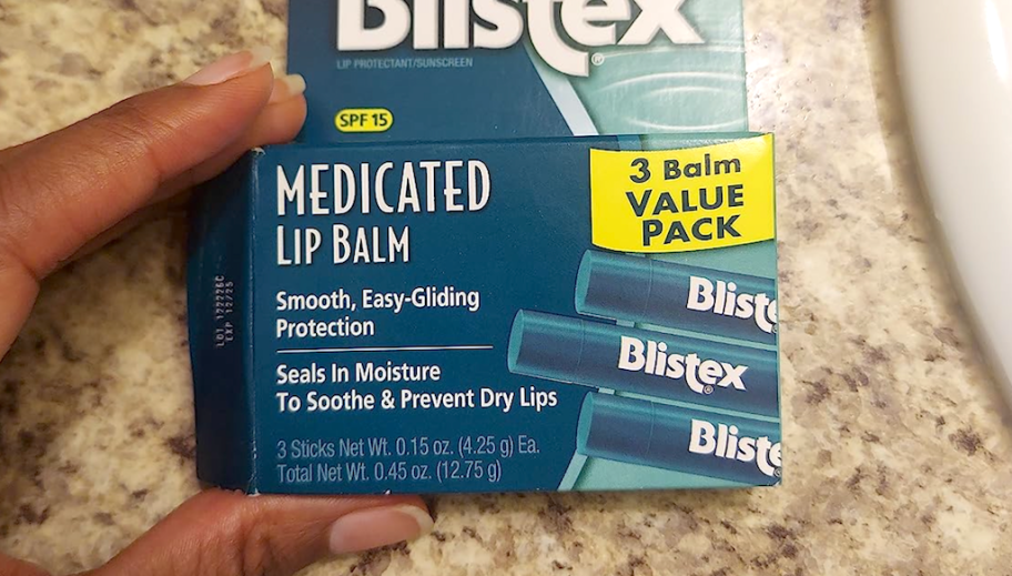 hand holding pack of Blistex lip balms