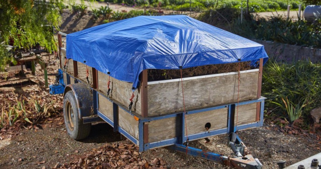 blue weather resistant tarp covering debris on trailer