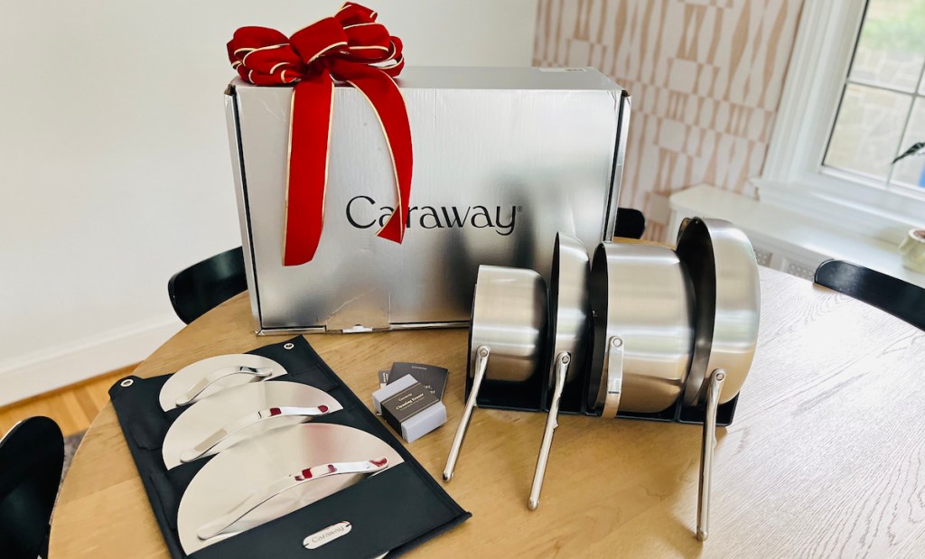 caraway stainless steel cookware set on wood table with box and big red bow