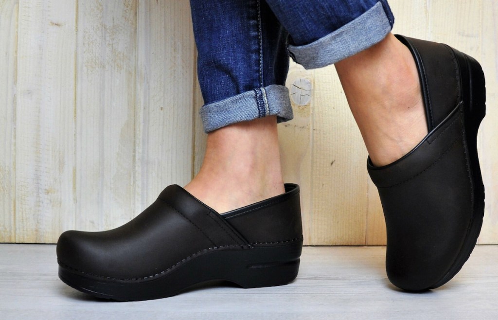close up of woman's feet wearing black dansko clogs
